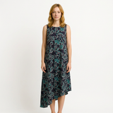 Woman in a dark blue and teal floral print cotton dress with an asymmetrical hem.