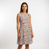 Woman in a sleeveless, knee-length dress made from white cotton lawn fabric with a vibrant pink and green floral print.