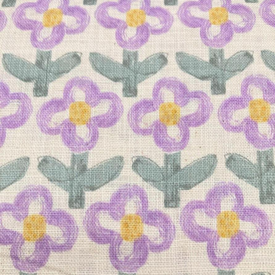 Hanako cotton printed poplin fabric with purple and yellow flowers and green leaves on a white background.