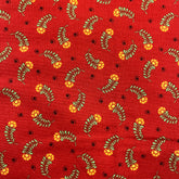 Red cotton fabric with a repeating pattern of yellow flowers, olive green leaves, and small black dots.