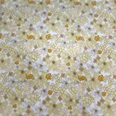 A close-up of a fabric or material sample with a repeating floral pattern in pale yellow, white, and muted gold tones.