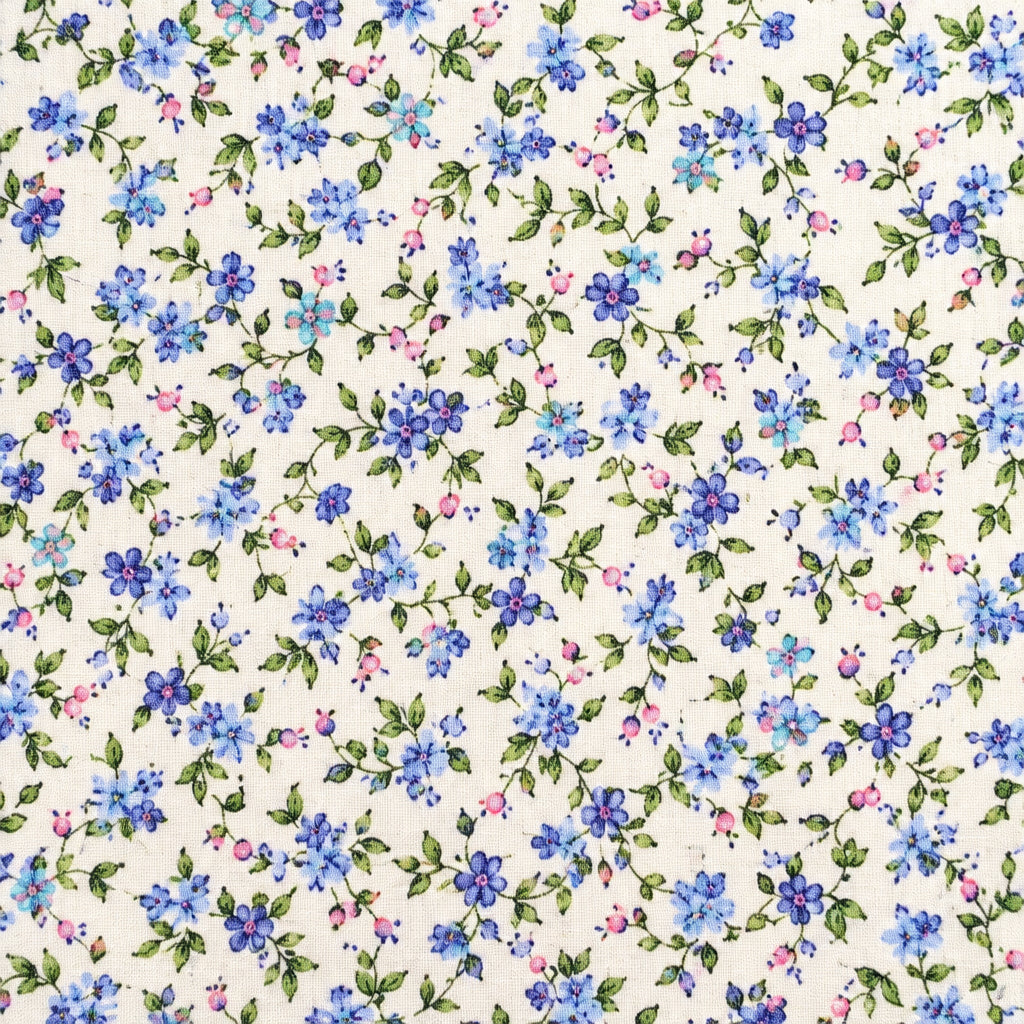 A close-up of a fabric yardage with a dense small floral print in blue, purple, and green on a cream background, held at the bottom by a hand. Other floral fabrics are partially visible on either side.
