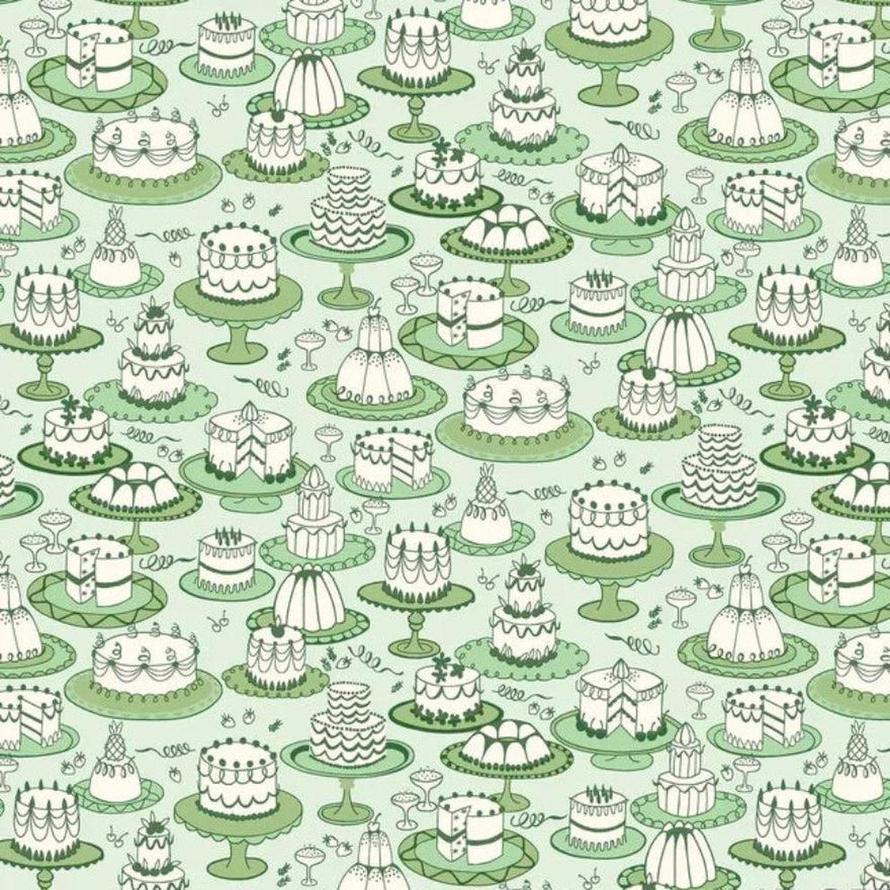 Light green fabric with white cakes on stands, priced at $11.00 a metre.