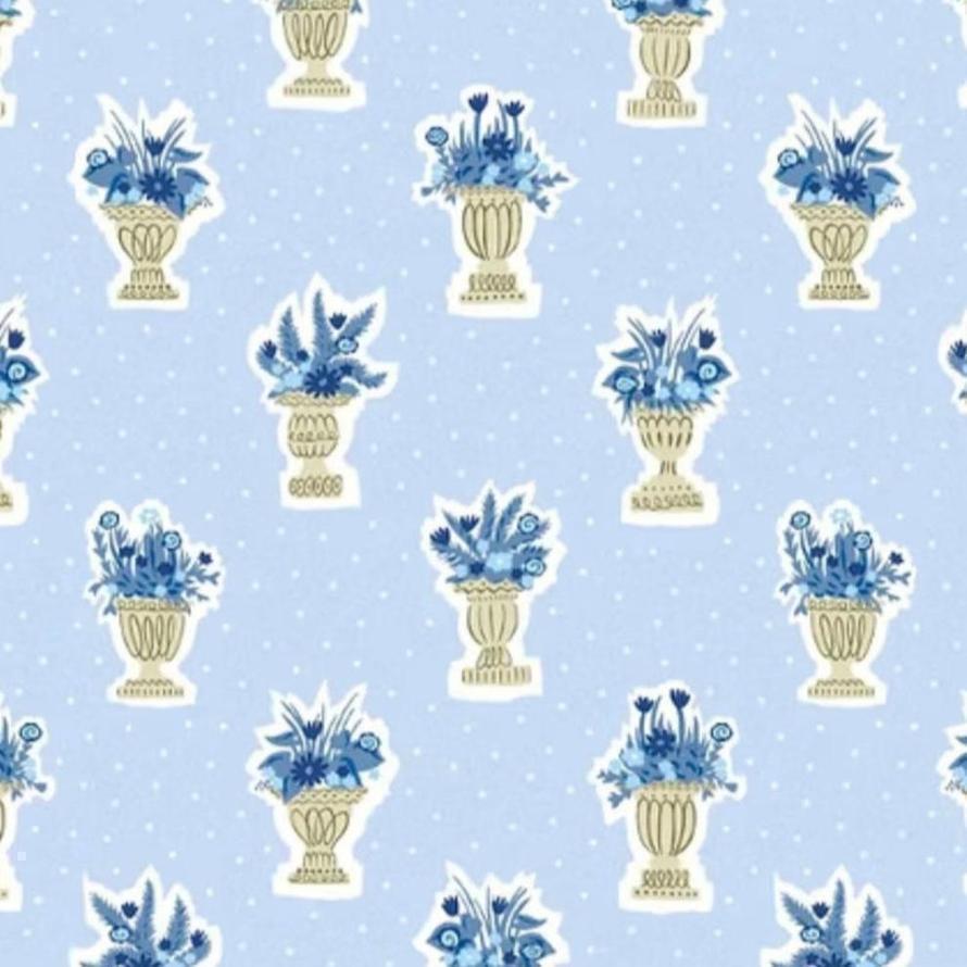 Light blue fabric with white polka dots and repeating pattern of blue floral arrangements in gold urns.
