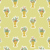 Light green fabric with a repeating pattern of gold vases holding colorful floral arrangements.