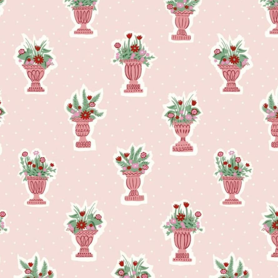 Pink fabric with a repeating pattern of ornate pink vases holding green and red floral arrangements.