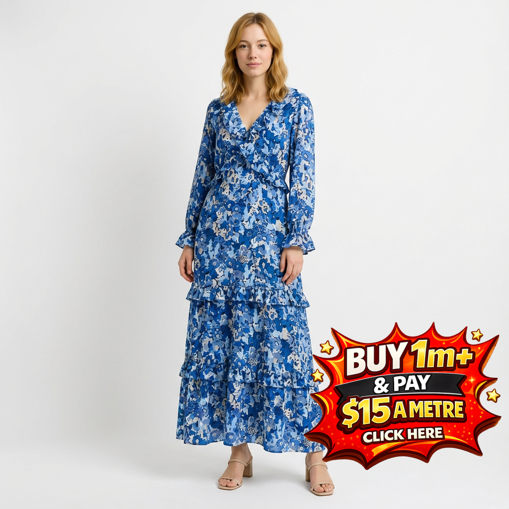 Woman in a blue floral tiered maxi dress with long sleeves and a ruffled V-neck.
