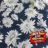 Seeded cotton shirting fabric with white daisy floral print on a dark blue background.