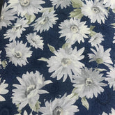 Seeded cotton shirting fabric with white daisy floral print on a dark blue background.