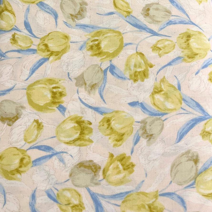 Sevenberry Tulip Cotton Print fabric with yellow and pale blue tulips on a light pink background.