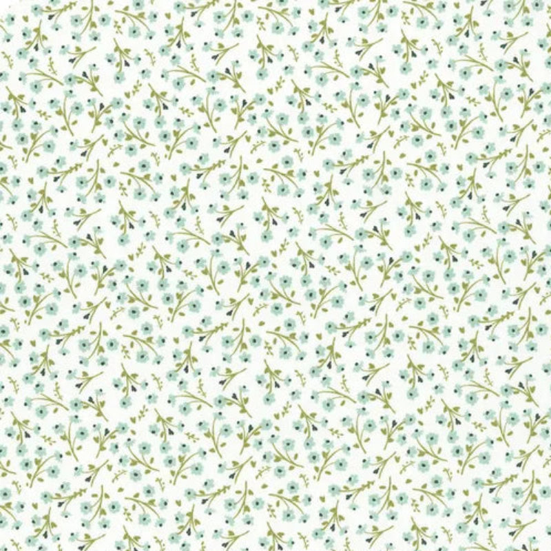 A repeating floral pattern on a white background with small mint green and pale blue flowers and olive-green stems, plus a 10-inch ruler along the bottom edge.