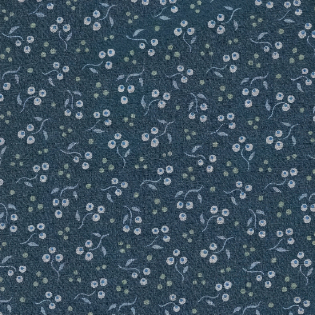 A close-up of a navy blue fabric with a delicate repeating pattern of small white flowers, light blue leaves, and pale green dots.