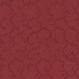 A close-up of a red fabric with a repeating dark red trellis or floral vine pattern, shown with a white ruler along the bottom edge for scale. The brand name 'moda' and website 'www.