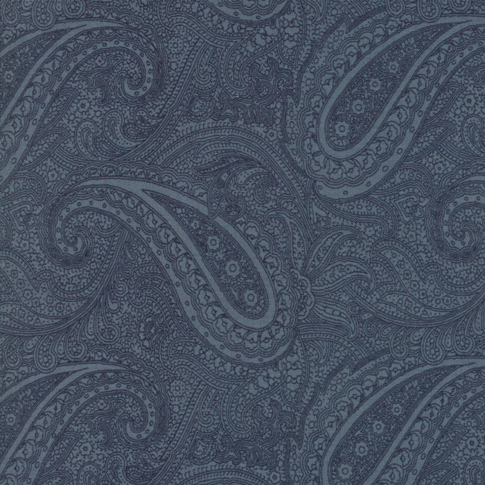 A close-up of a fabric or wallpaper pattern featuring a detailed paisley design in shades of slate blue and navy.