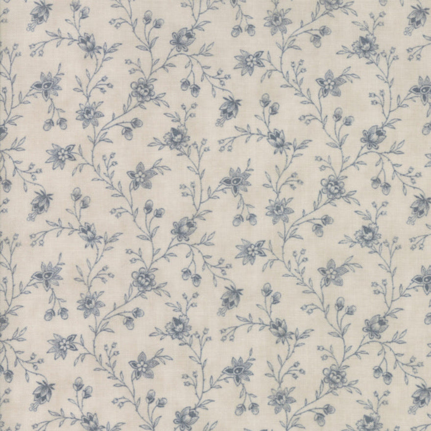 A close-up of a fabric or wallpaper pattern featuring a delicate blue floral vine design on a warm cream background.