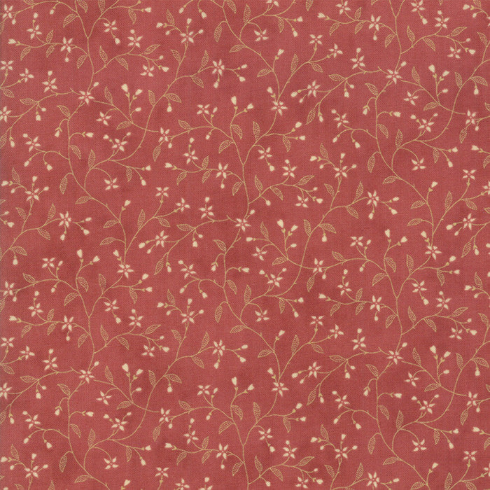 A close-up of a dusty rose red fabric or wallpaper featuring a delicate repeating pattern of light tan vines, leaves, and small white flowers.