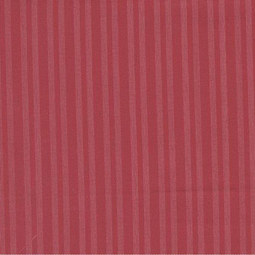 A close-up of a dusty rose red fabric with fine vertical stripes, featuring a white ruler at the bottom edge for scale with the Moda Fabrics logo.