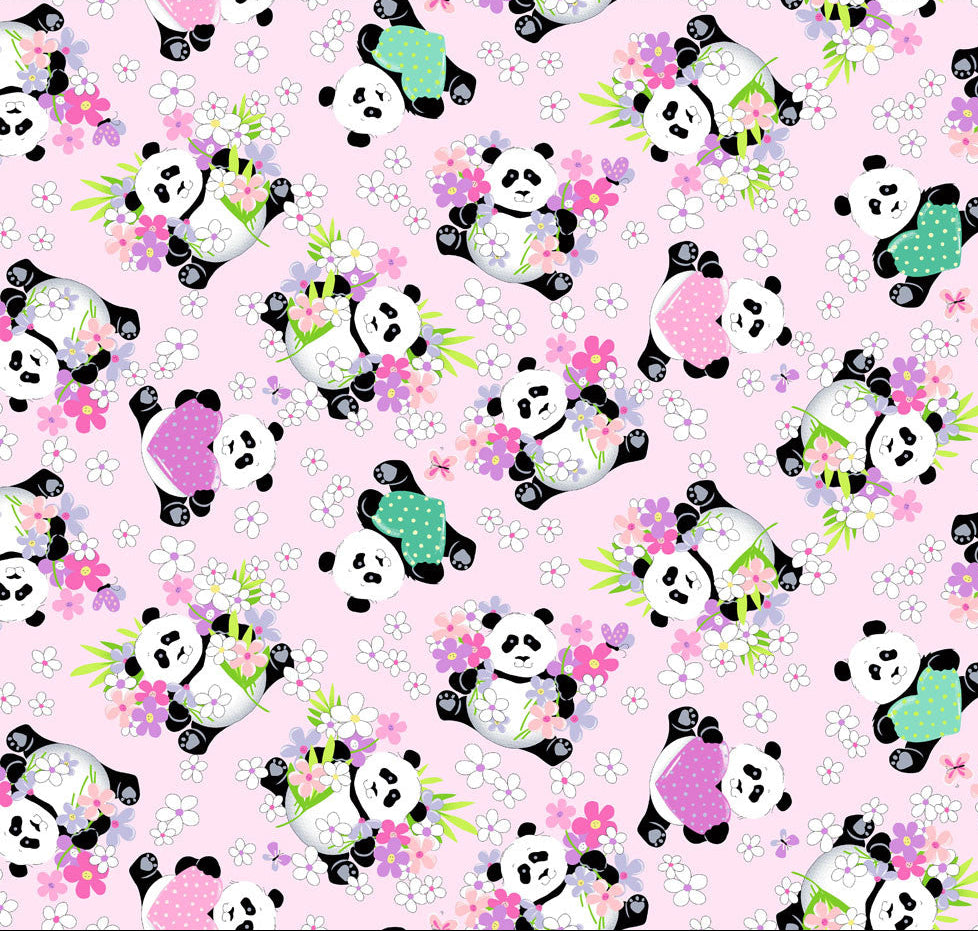A close-up of a repeating fabric pattern featuring cartoon pandas in black and white wearing colorful outfits, surrounded by pink flowers and green leaves on a light pink background. A white ruler with black markings is visible along the top edge.