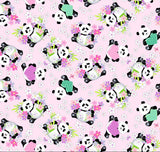 A close-up of a repeating fabric pattern featuring cartoon pandas in black and white wearing colorful outfits, surrounded by pink flowers and green leaves on a light pink background. A white ruler with black markings is visible along the top edge.