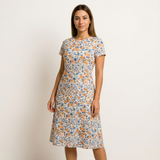 Woman wearing a short-sleeved, knee-length dress made from light cotton lawn fabric with a blue and orange floral print.