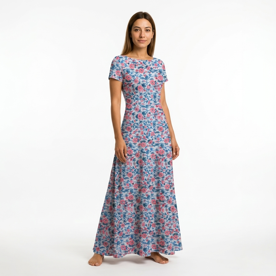 Woman in a light blue cotton maxi dress with pink and blue floral print, short sleeves, and boat neck.