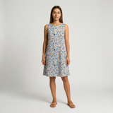 Woman in a sleeveless cotton lawn dress with a vibrant blue, pink, and yellow floral print.