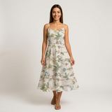 Woman in a white cotton lawn dress with delicate green vines and colorful floral print.