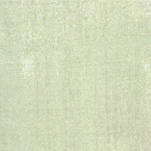 A close-up of a light sage green textured fabric with a subtle woven linen-like pattern.