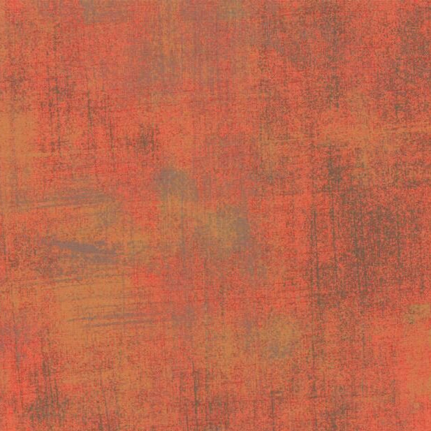 A close-up of a textured surface with a mottled, distressed pattern in warm rust, terracotta, orange, and brown tones.