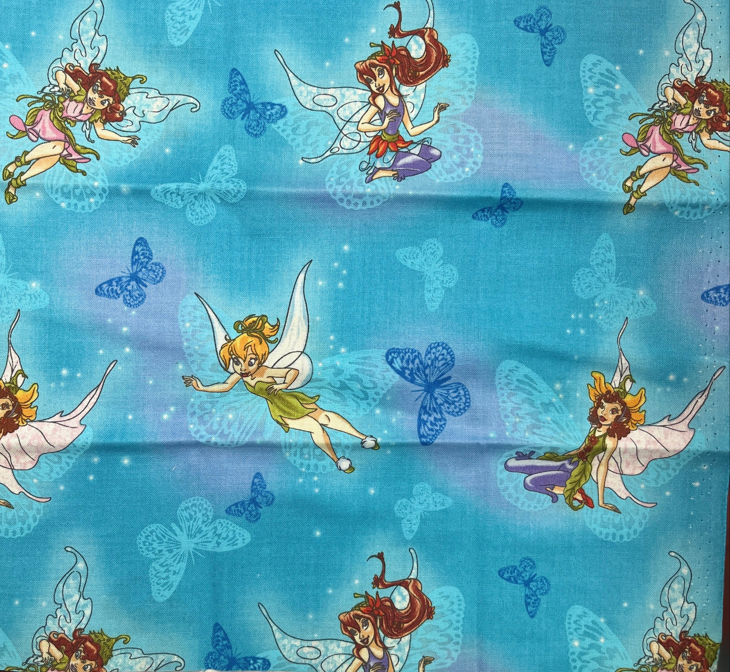 Fabric with fairy and butterfly pattern on a blue background