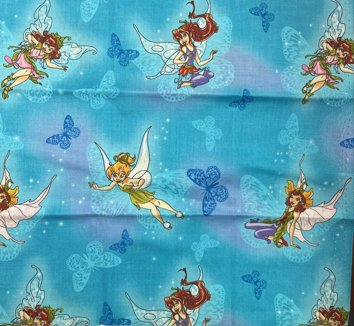 Fabric with fairy and butterfly pattern on a blue background