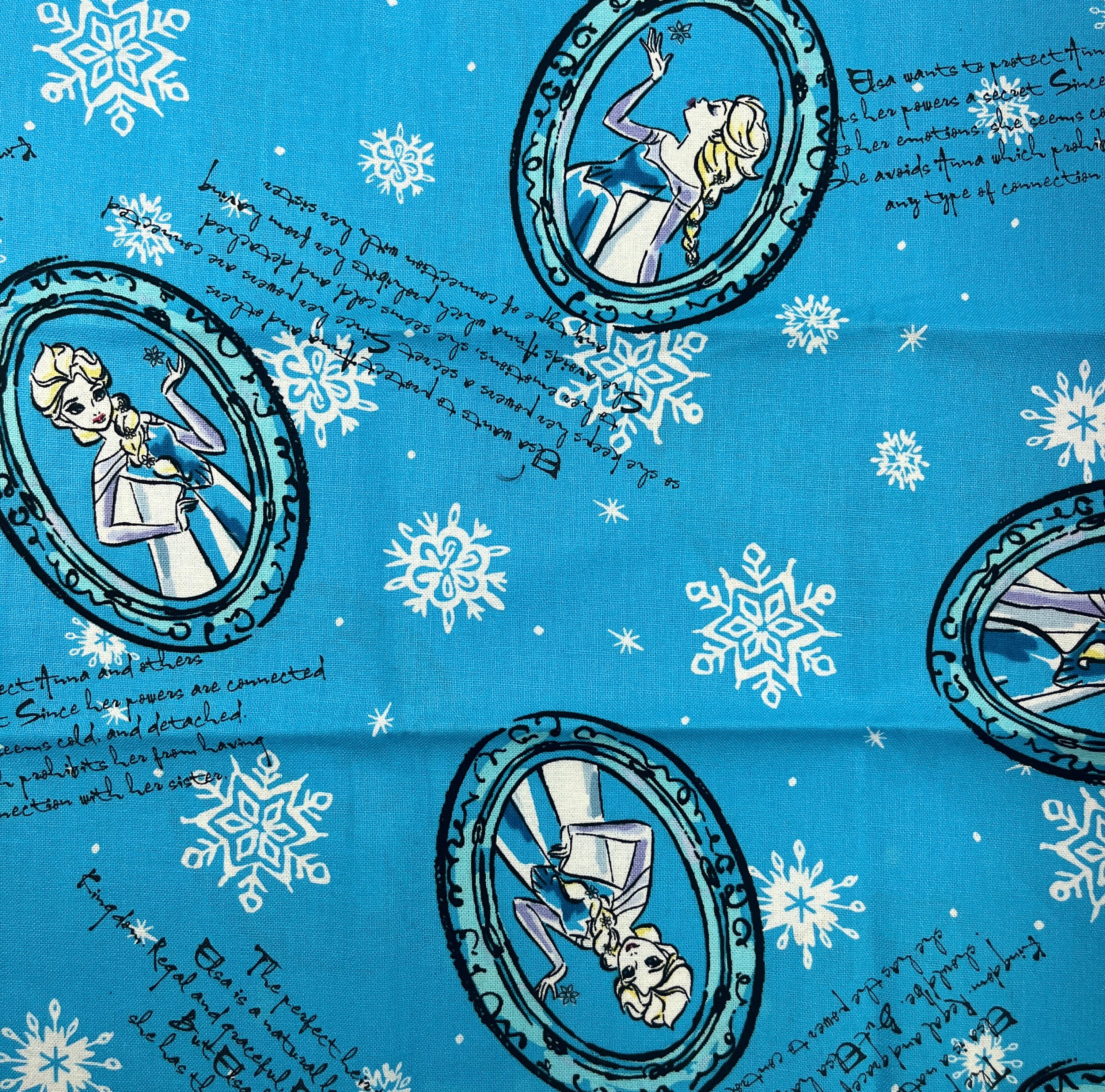 Frozen-themed fabric with Elsa and Anna designs on a blue background