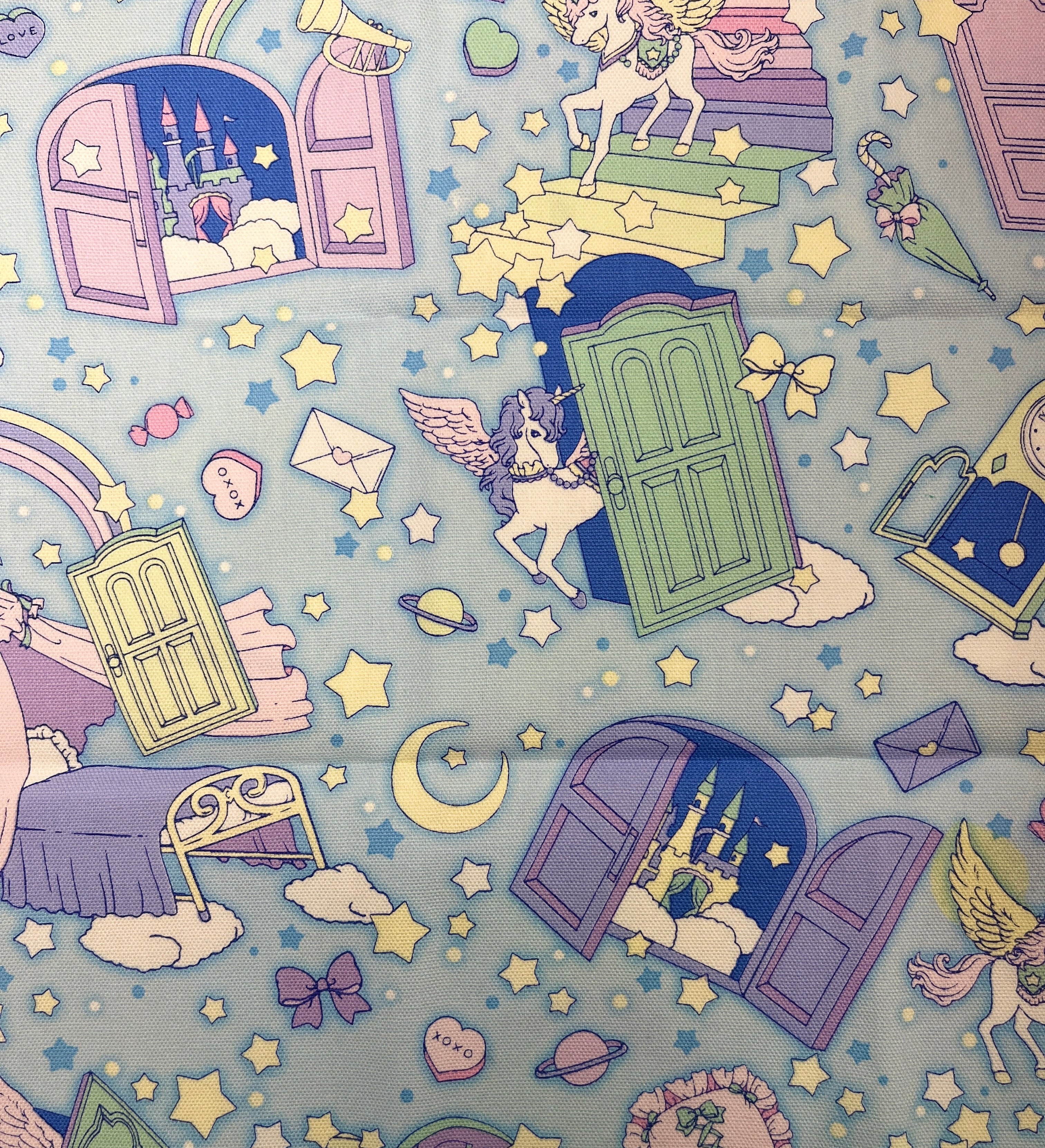 Children's paper with unicorn, castle, and rainbow illustrations on a blue background.