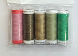 Set of colorful thread spools in a clear package on a white sheet with a pen and floral-patterned object.