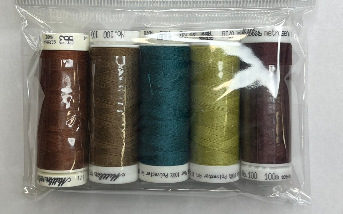 Set of thread spools in a clear package with a label on a white surface.