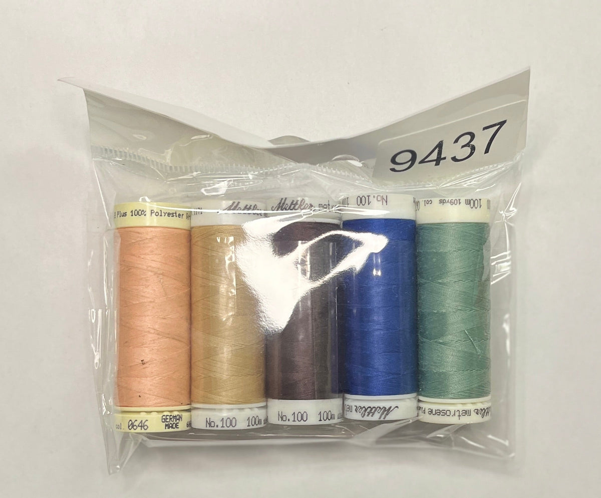 Set of thread spools in a clear package on a wooden surface