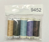 Set of sewing threads in a clear package on a wooden surface