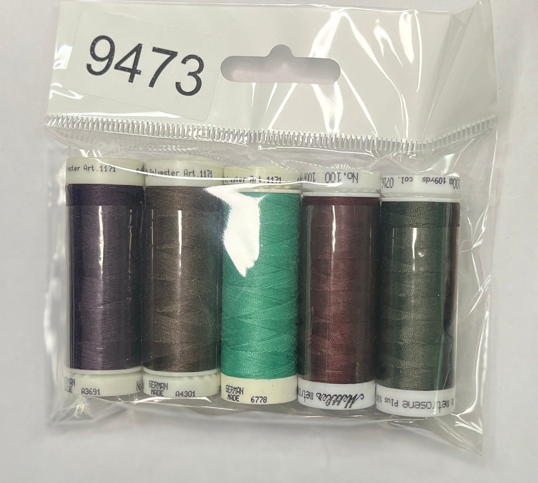 Set of sewing threads in a clear package on a wooden surface