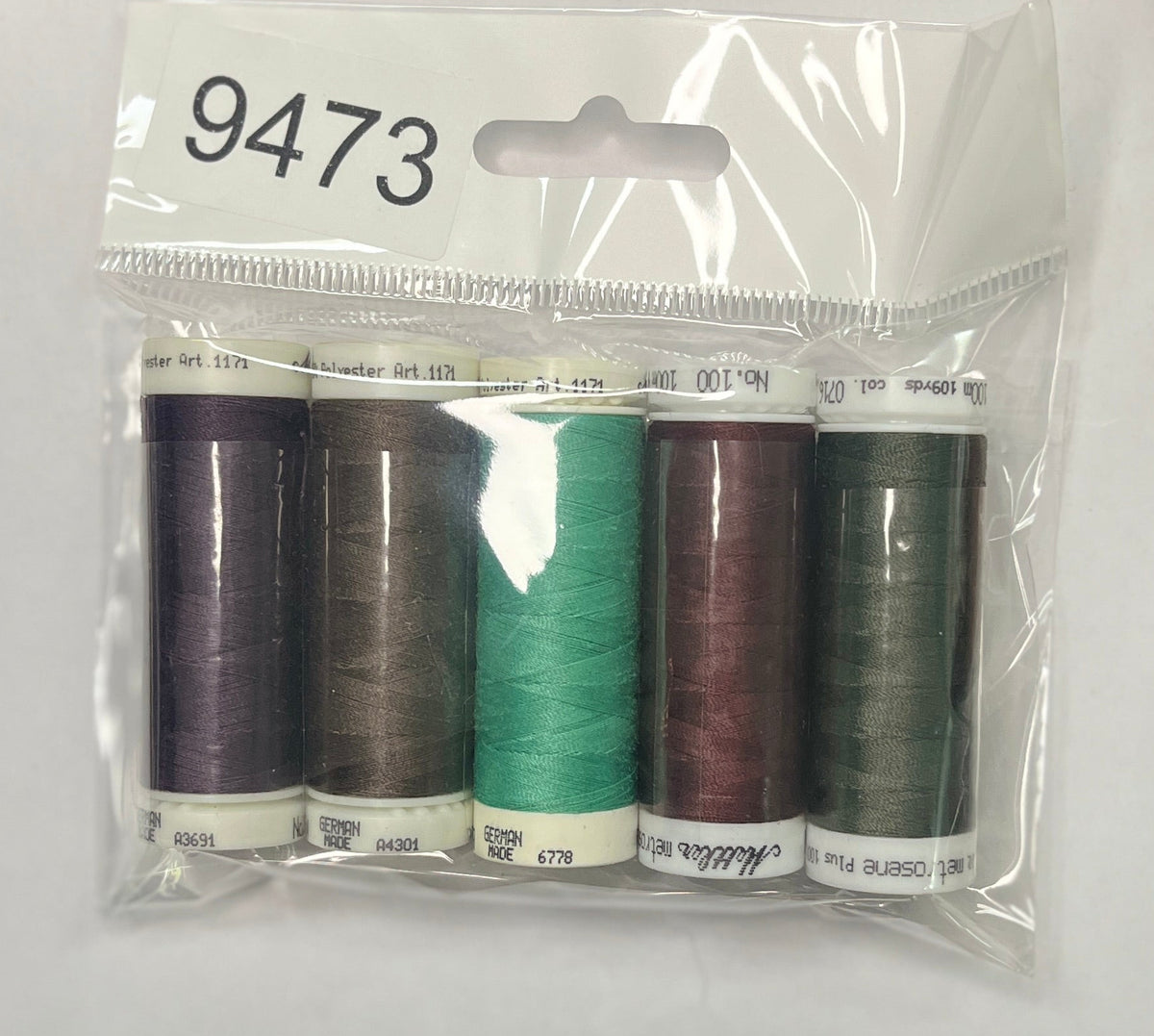 Set of sewing threads in a clear package on a wooden surface