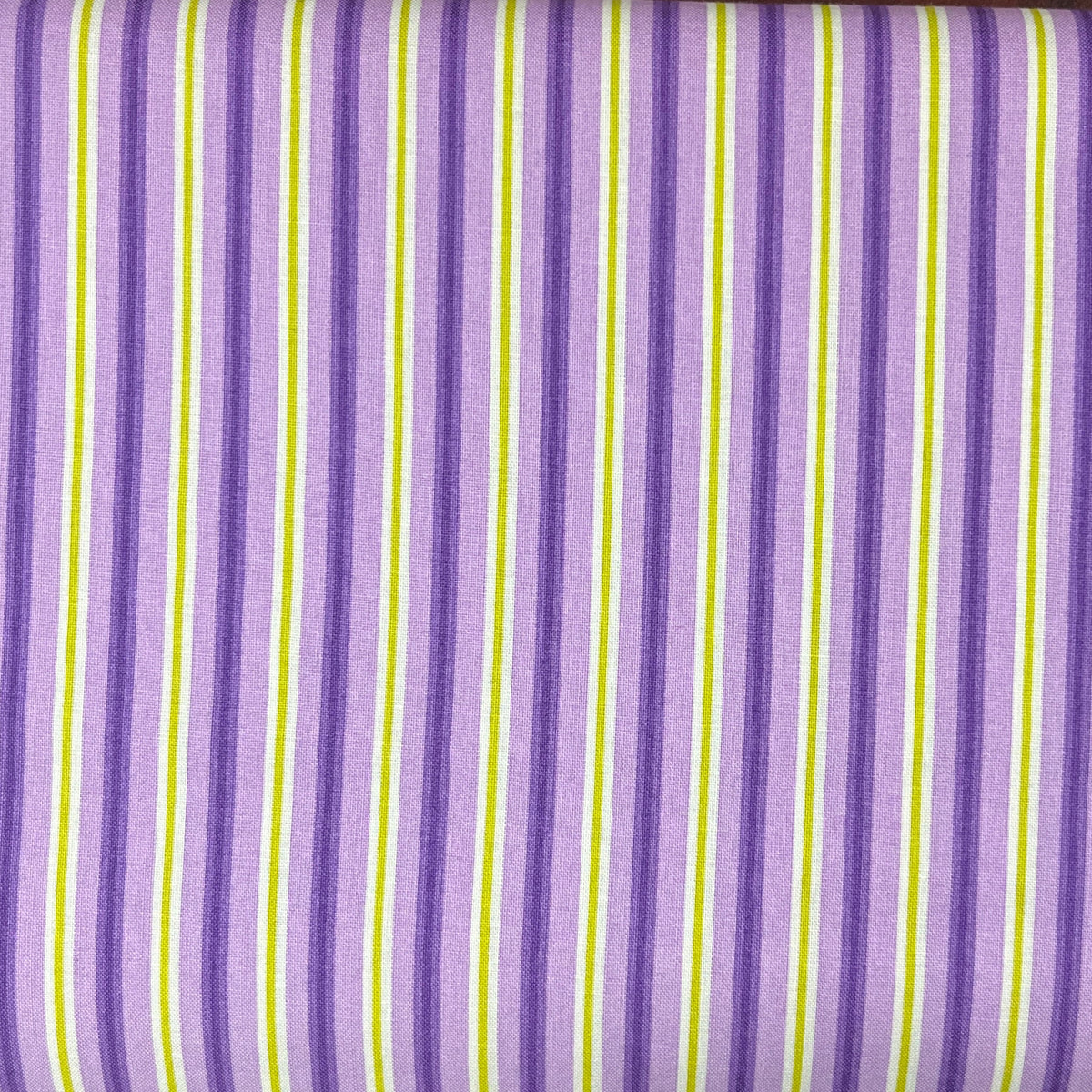 A folded piece of fabric with a purple, white, and lime green striped pattern, laid flat on a dark wood surface.