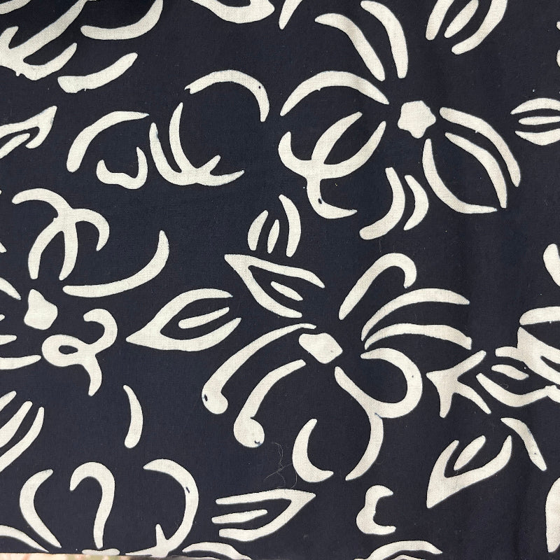 A close-up of a navy blue fabric with a white hand-drawn style floral and leaf pattern.