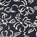 A close-up of a navy blue fabric with a white hand-drawn style floral and leaf pattern.