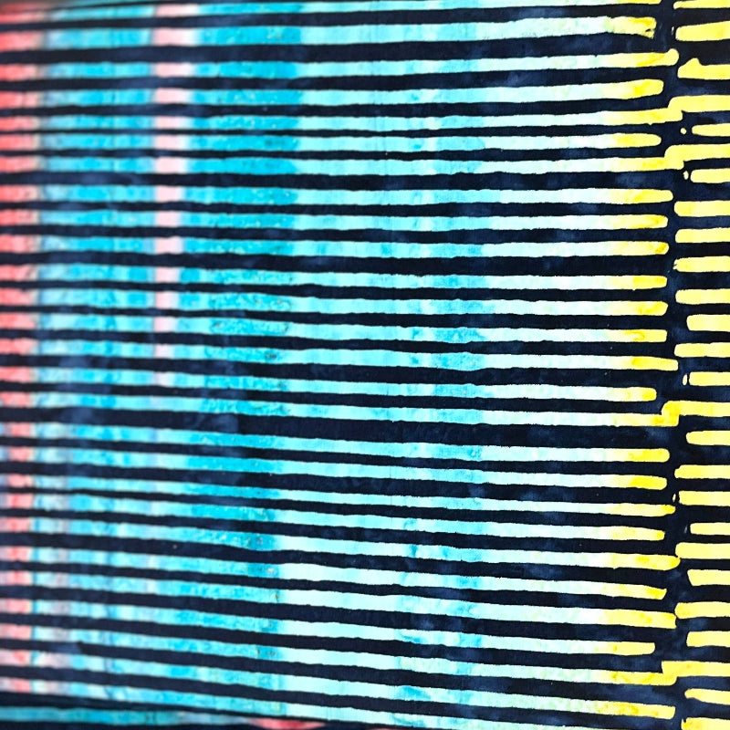 A close-up of a striped fabric accessory, likely a wallet or pouch, featuring horizontal bands of yellow, black, blue, and red-pink.