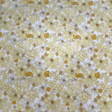 A close-up of a fabric or material sample with a repeating floral pattern in pale yellow, white, and muted gold tones.