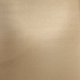 A close-up of a beige fabric or material sample shown vertically, with a blurred desk background visible around it.