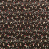 A close-up of a dark brown patterned fabric or wallpaper featuring a repeating floral and vine motif in cream, red, and muted blue, with a decorative border visible along the left edge.