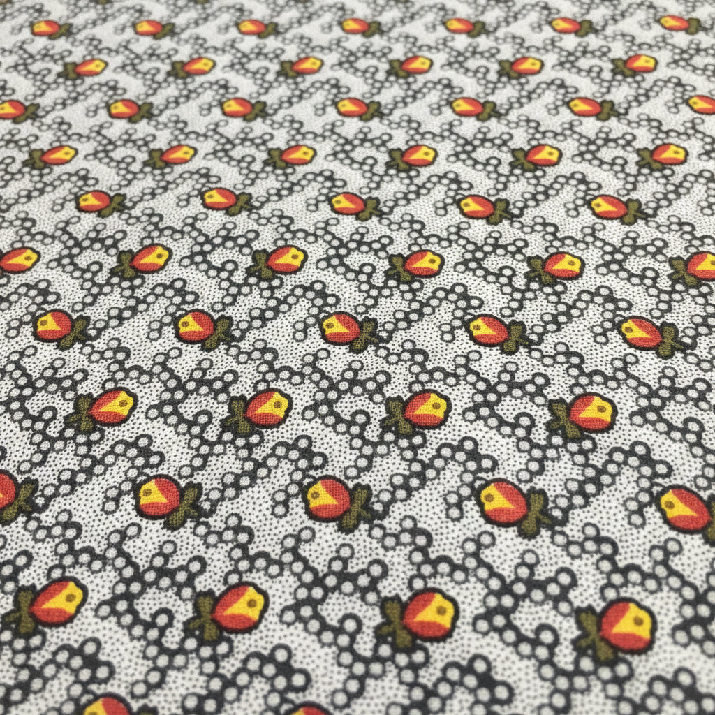 A close-up of a necktie featuring a repeating pattern of small orange and yellow flowers with green leaves on a white background.