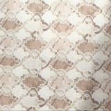 A close-up of a beige and cream patterned fabric or wallpaper sample with a repeating geometric floral design, held by a hand on the right side.