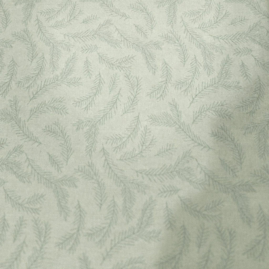 A close-up of a light-colored fabric or wallpaper with a repeating pale blue leafy vine pattern, shown against a background with pink and red edges.