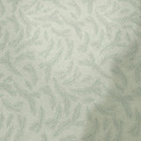 A close-up of a light-colored fabric or wallpaper with a repeating pale blue leafy vine pattern, shown against a background with pink and red edges.